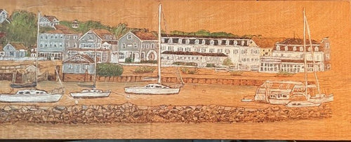 Hand‑burned mahogany panorama of Block Island harbor with sailboats, shingled waterfront buildings, and rocky breakwater